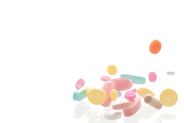 Pílulas coloridas de várias formas em fundo branco