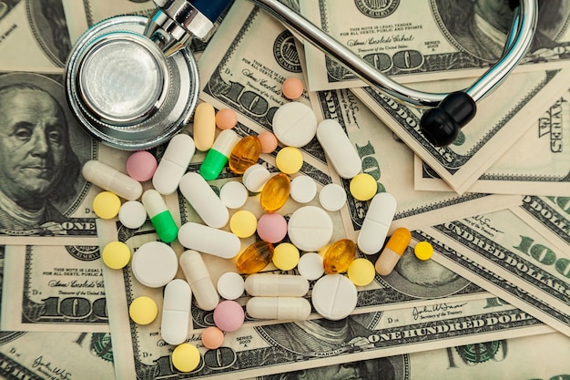 Pílulas de dinheiro pílulas de remédios em notas de dólar em um fundo azul pílulas de coronavírus covid estão em um h