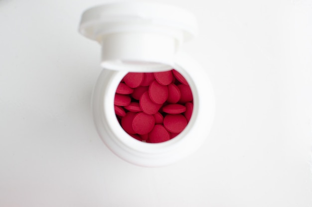 Pílulas de remédio em pacote branco pílulas e pílulas de remédio na cor vermelha dentro da borda redonda na superfície branca Conceito medicina farmácia paciente hospital doenças saúde e tratamentos