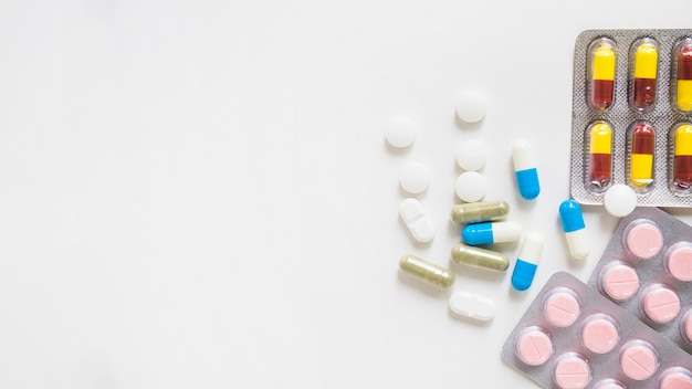 Pílulas e blister de medicamentos em fundo branco