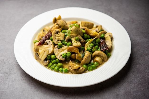 Pilz-Erbsen-Curry mit geröstetem Knoblauch Indisches Essen in einer Schüssel serviert