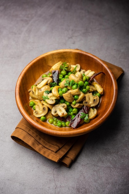 Pilz-Erbsen-Curry mit geröstetem Knoblauch Indisches Essen in einer Schüssel serviert