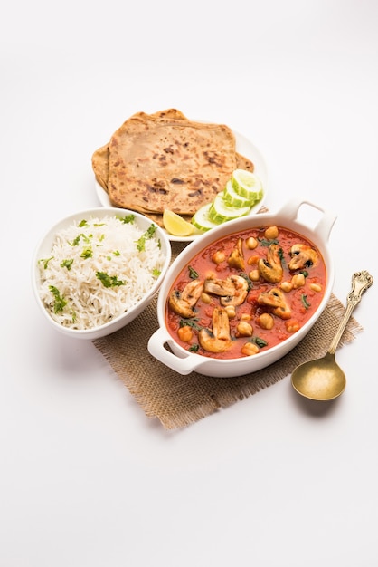 Pilz-Sabzi in Tomaten-Curry mit Kichererbsen und Spinat, indisches Hauptgang-Menü serviert mit Paratha und gekochtem weißem Reis