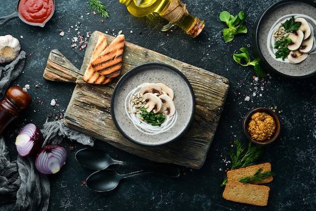 Pilzcremesuppe in einer schwarzen Schüssel Vegetarisches Menü Draufsicht Freier Platz für Ihren Text Rustikaler Stil