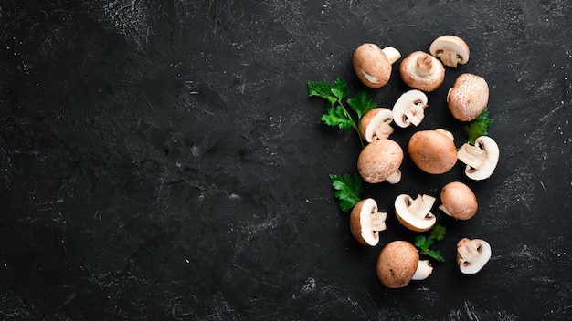 Pilze auf einem schwarzen Steinhintergrund Draufsicht der Champignons Freier Kopienraum