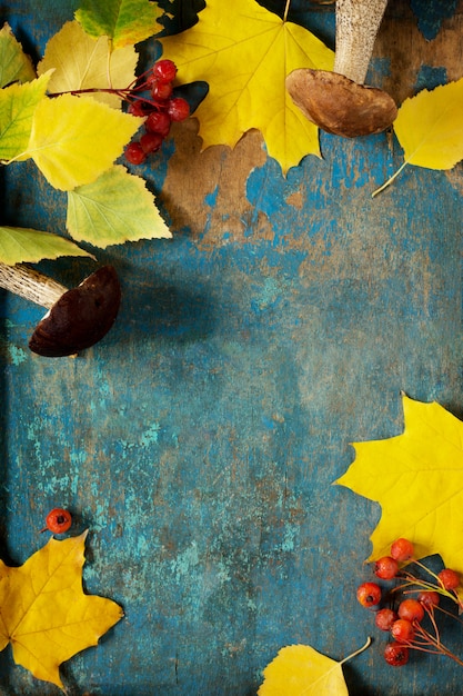 Pilze und Herbstlaub auf einem Holztisch