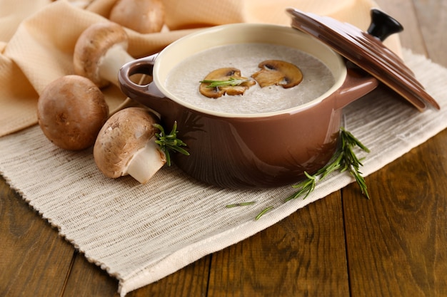 Pilzsuppe im Topf, auf Holztisch