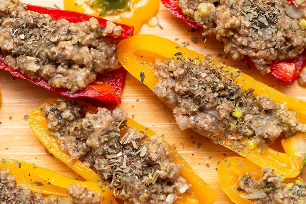 Foto pimenta amarela e vermelha com delicioso recheio de carne moída em mesa de madeira