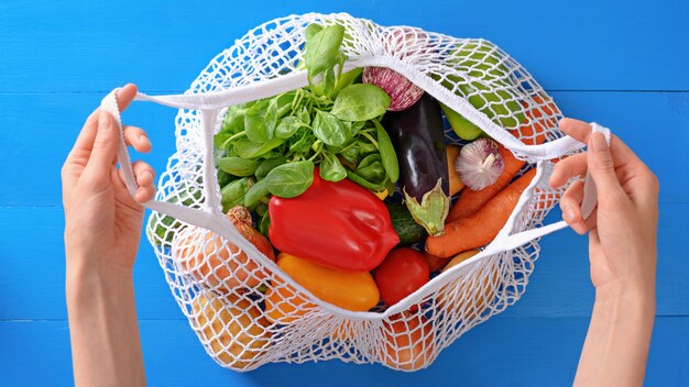 Pimenta, berinjela, espinafre, tomate, cenoura em um saco de barbante branco