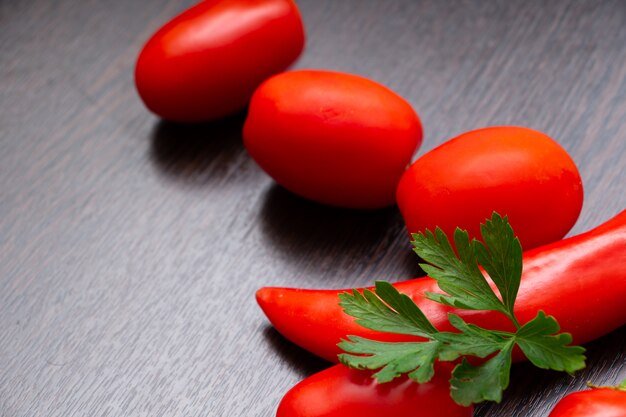 Pimenta e tomate em uma mesa de madeira escura