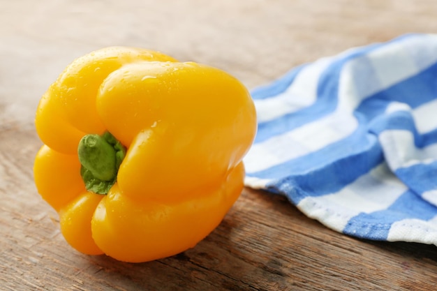 Pimenta em guardanapo de algodão listrado contra fundo de madeira de perto