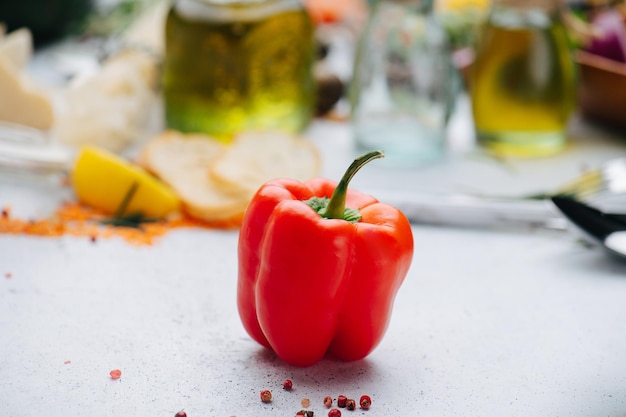 Pimenta páprica vermelha vibrante na frente do óleo em garrafas borradas no fundo