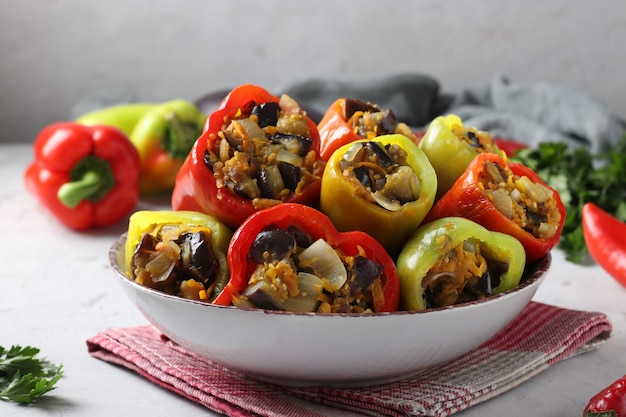 Pimenta recheada com berinjela, cebola e cenoura na mesa cinza claro, comida vegetariana, closeup