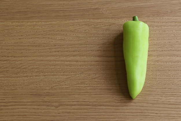 Pimenta verde em fundo de madeira.