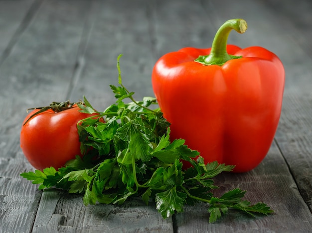 Pimenta vermelha búlgara com tomate e salsa na mesa preta