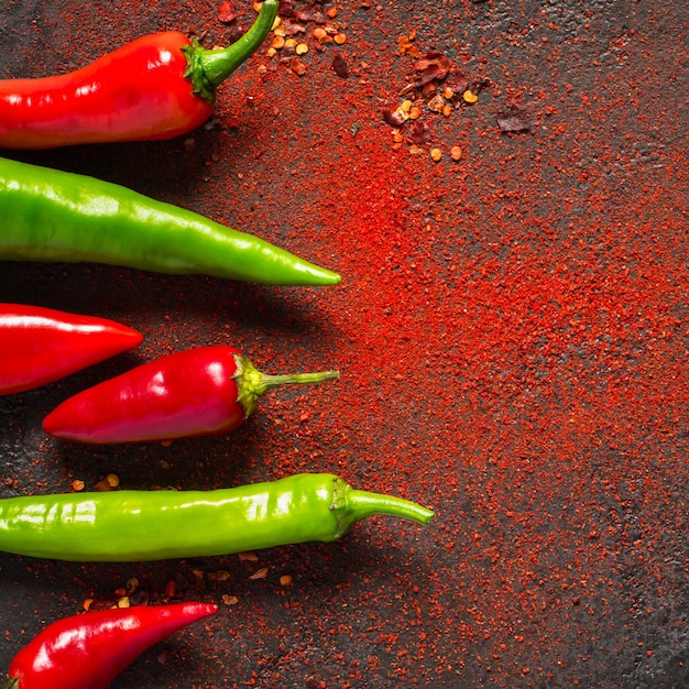 Pimenta vermelha e verde e pimenta moída seca em um fundo escuro