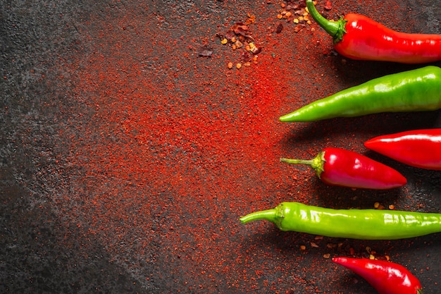 Pimenta vermelha e verde e pimenta seca em um fundo escuro.