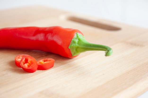 Pimenta vermelha em uma placa de cozinha de madeira Cozinhar alimentos