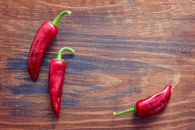 Pimenta vermelha quente em um fundo de madeira. Copie o fundo do espaço