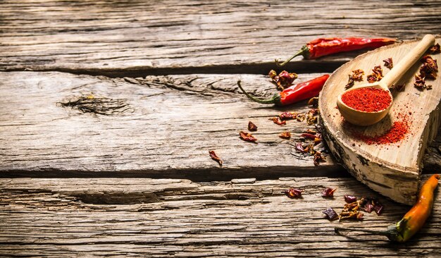 Pimenta vermelha seca e moída em carvalho carrinho na mesa de madeira.