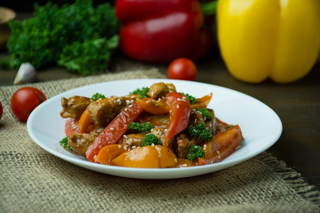 Pimentão e salada de carne. Comida asiática. Salada quente colorida. Fundo escuro. Espaço para texto.