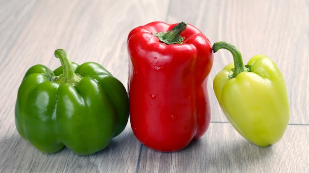 Pimentão três colorido em uma mesa de madeira. comida vegetal