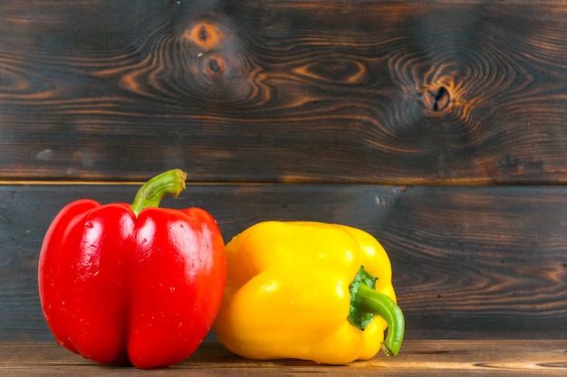 Foto pimentão vermelho e amarelo na mesa de madeira