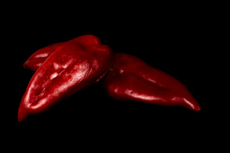 Foto pimentão vermelho sobre um fundo preto.