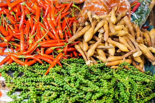 Foto pimentas verdes frescas, pimentões vermelhos e pandurata de boesenbergia ou krachai de tailandês.