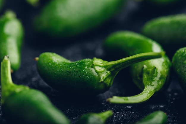 Pimentas verdes maduras do Jalapeno no fundo concreto