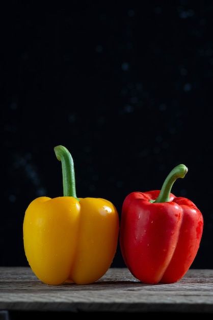 Pimentões vermelhos e amarelos para salada em uma mesa de madeira em um conceito minimalista de estilo rústico