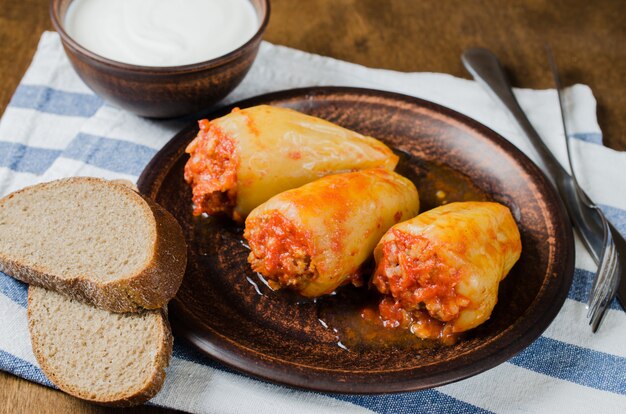 Pimentos recheados com arroz e carne picada guisado em tomate, pão de centeio. comida rústica.