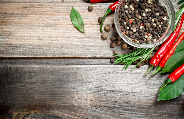 Foto pimienta guisantes en un bol con hojas de laurel y pimiento rojo