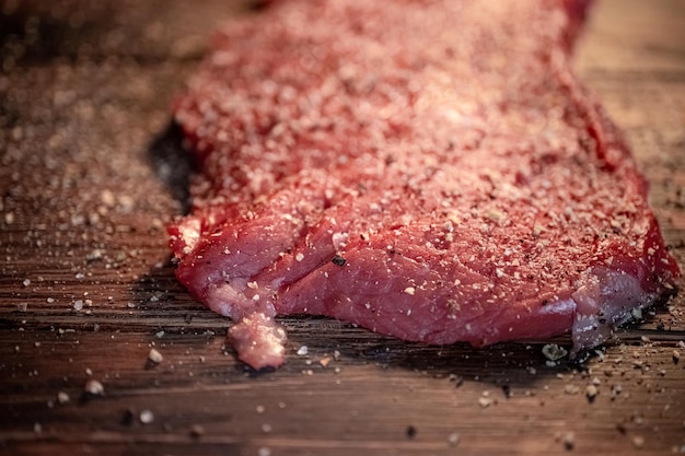 Pimienta mezclada y especias en el bistec de carne cruda de cerca