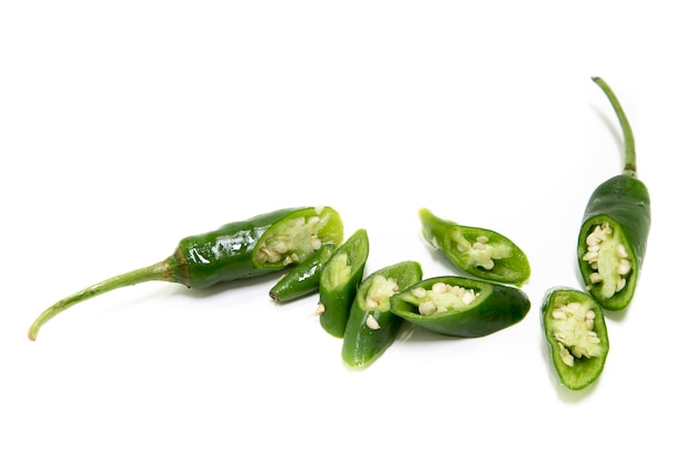 Pimientas verdes picadas contra un fondo blanco