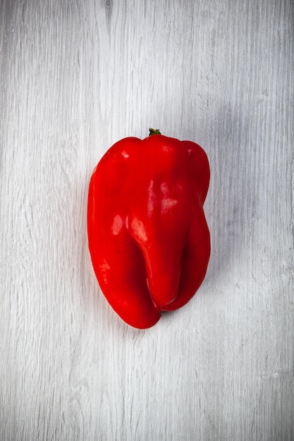 Un pimiento dulce rojo sobre mesa blanca