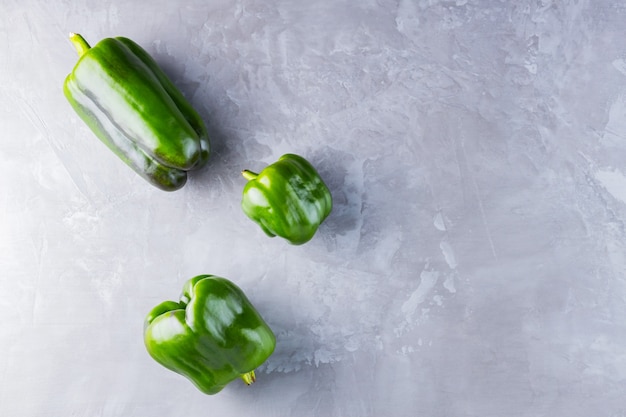 Pimiento feo sobre fondo gris definitivo. Pimiento morrón verde de cosecha propia deformado. Copia espacio