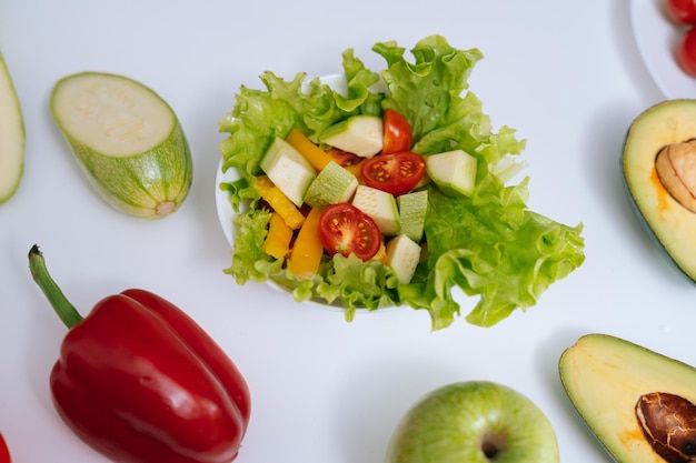 Pimiento, manzana, calabacín, aguacate, ensalada de verduras sobre un fondo blanco, primer plano. Concepto de alimentación saludable.