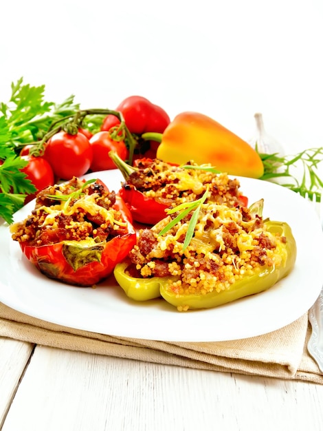 Pimiento relleno de carne y cuscús en plato blanco sobre tablero ligero