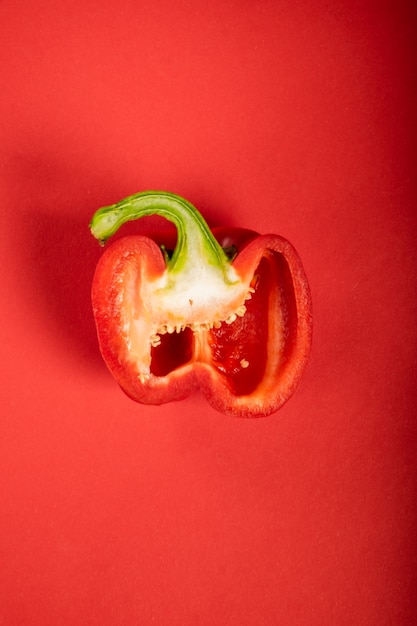 Foto pimiento en rodajas jugoso sobre una superficie de color rojo brillante