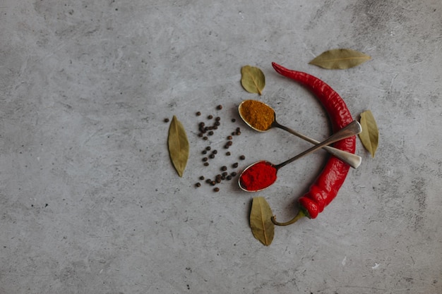 Un pimiento rojo y una cuchara con especias