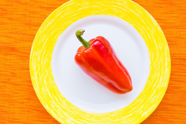 Un pimiento rojo en un plato colorido closeup