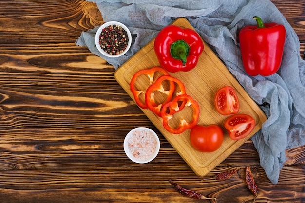 Pimiento, tomate, sal, especias diferentes en madera