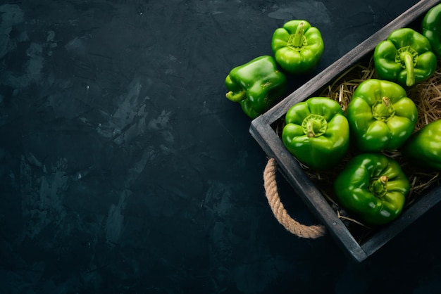 Pimiento verde fresco en una caja de madera alimentos orgánicos vista superior espacio libre para texto