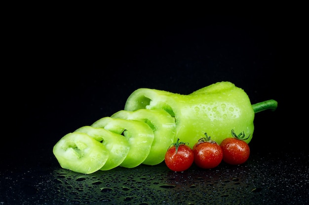 pimiento verde y pequeños tomates cherry en negro