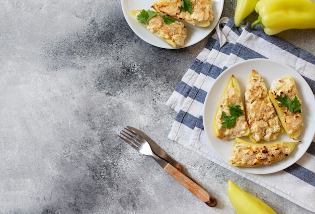 Pimientos asados rellenos de queso y hierbas en un plato blanco. Plato característico de la cocina balcánica. Cocina serbia. Fondo gris, vista superior, espacio de copia