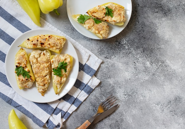 Pimientos asados rellenos de queso y hierbas en un plato blanco. Plato característico de la cocina balcánica. Cocina serbia. Fondo gris, vista superior, espacio de copia