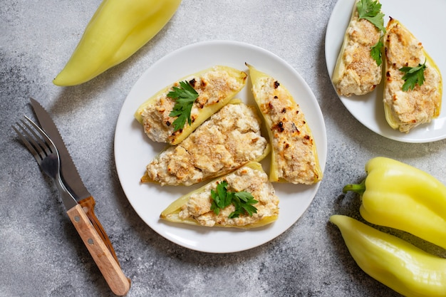 Pimientos asados rellenos de queso y hierbas en un plato blanco. Plato característico de la cocina balcánica. Cocina serbia. Fondo gris, vista superior, espacio de copia