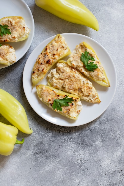 Pimientos asados rellenos de queso y hierbas en un plato blanco. Plato característico de la cocina balcánica. Cocina serbia. Fondo gris, vista superior, espacio de copia