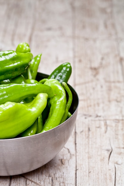 Pimientos crudos verdes frescos en un recipiente de metal